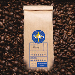 North Koffee bag of swiss-water-process Decaf beans surrounded by roasted beans