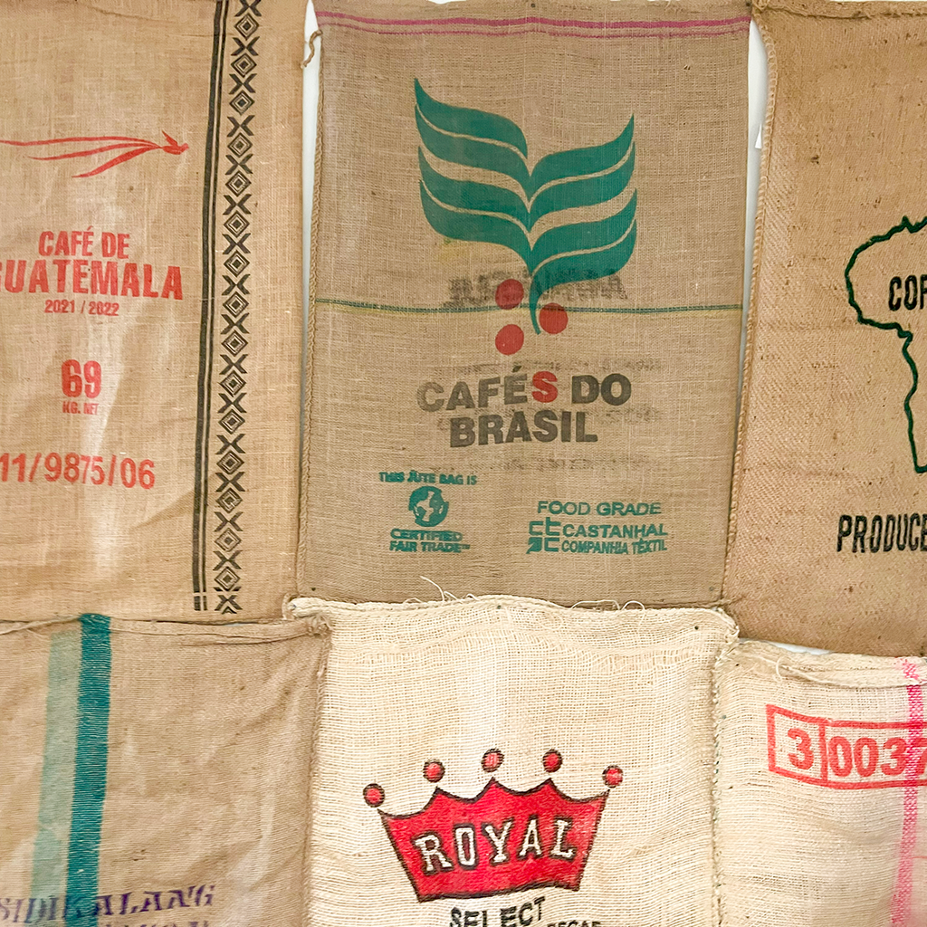 a grouping of jute coffee bags hanging on a wall