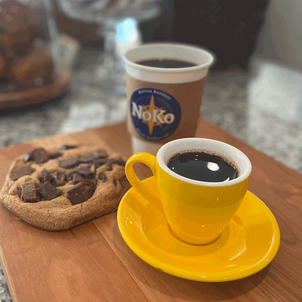 cup of North Koffee Single Origin with a chunky chocolate cookie in the North Koffee Cafe